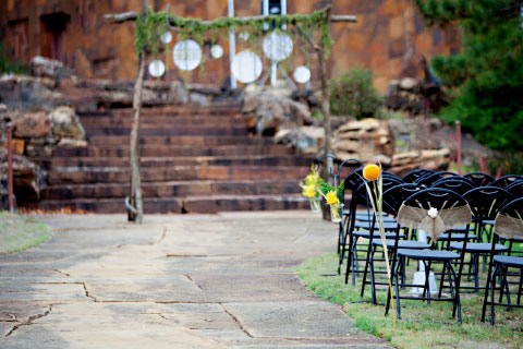 A beautifully decorated wedding ceremony in front of the steps at Woolaroc