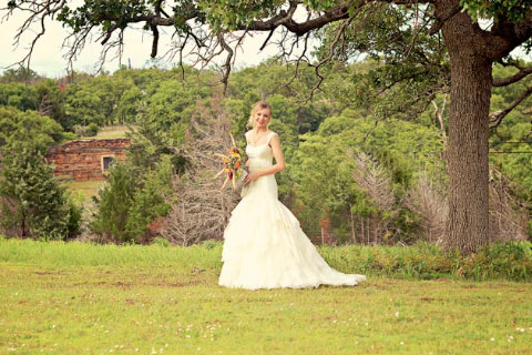 A bride taking pictures surrounded by Woolaroc's beautiful grounds